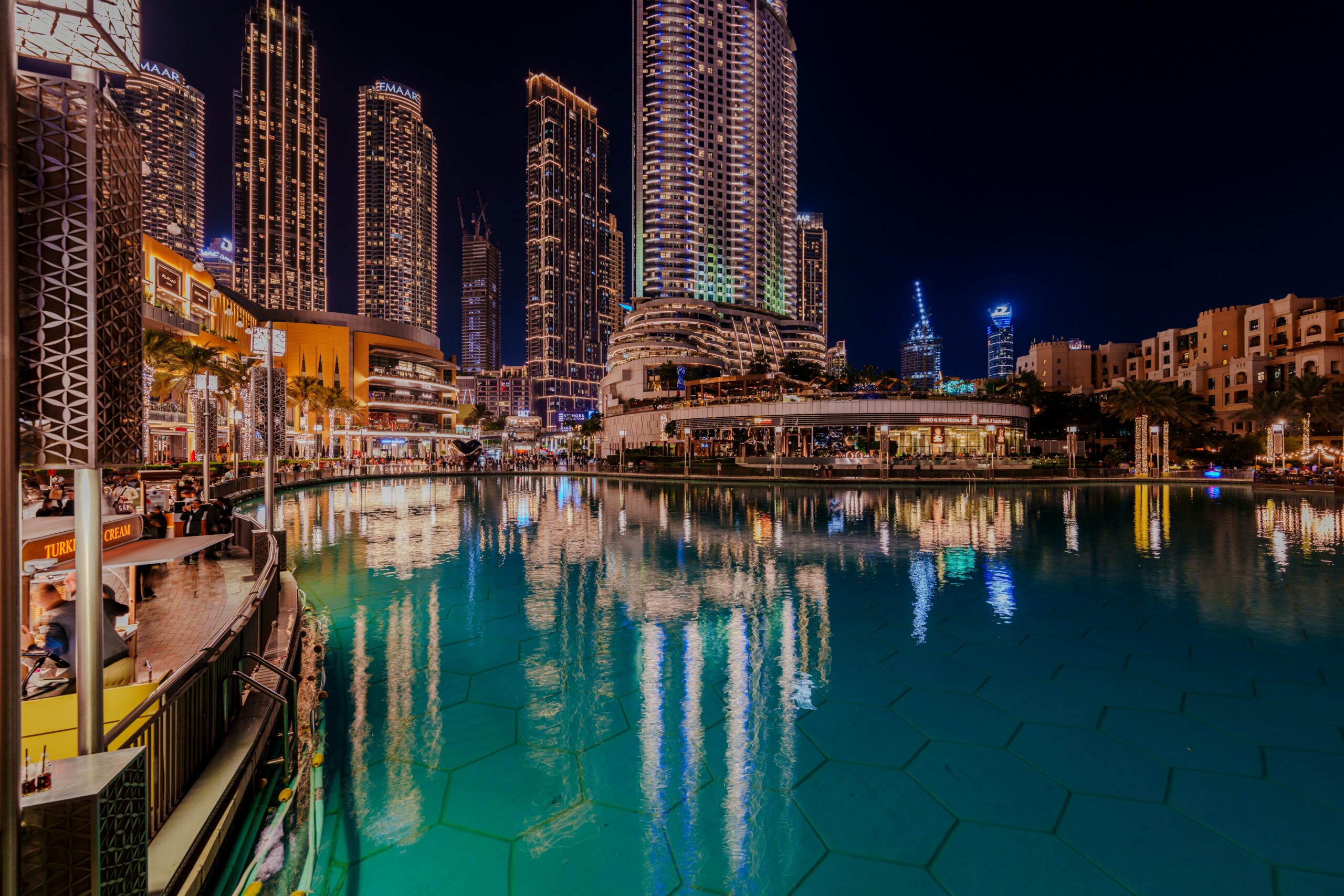 Captivating night view of Dubai's cosmopolitan skyline reflecting in a serene pond. kali travels