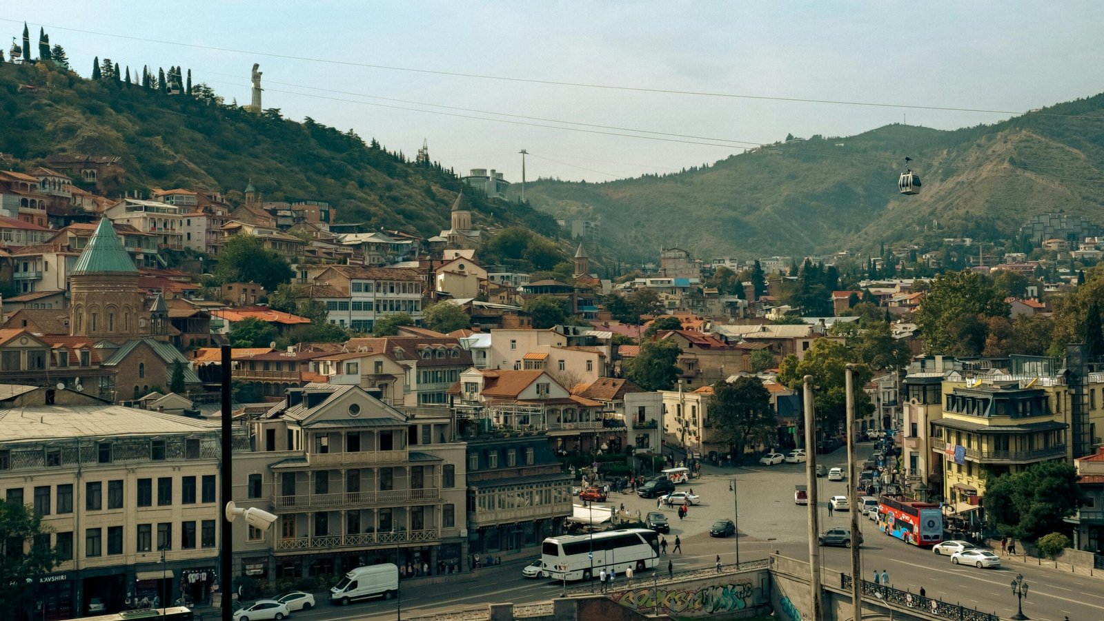 A scenic view of Tbilisi, Georgia, showcasing historic architecture and cable car over the city. kwesttzadventure georgia